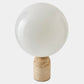 Table lamp with a white spherical shade and beige base on a light gray background