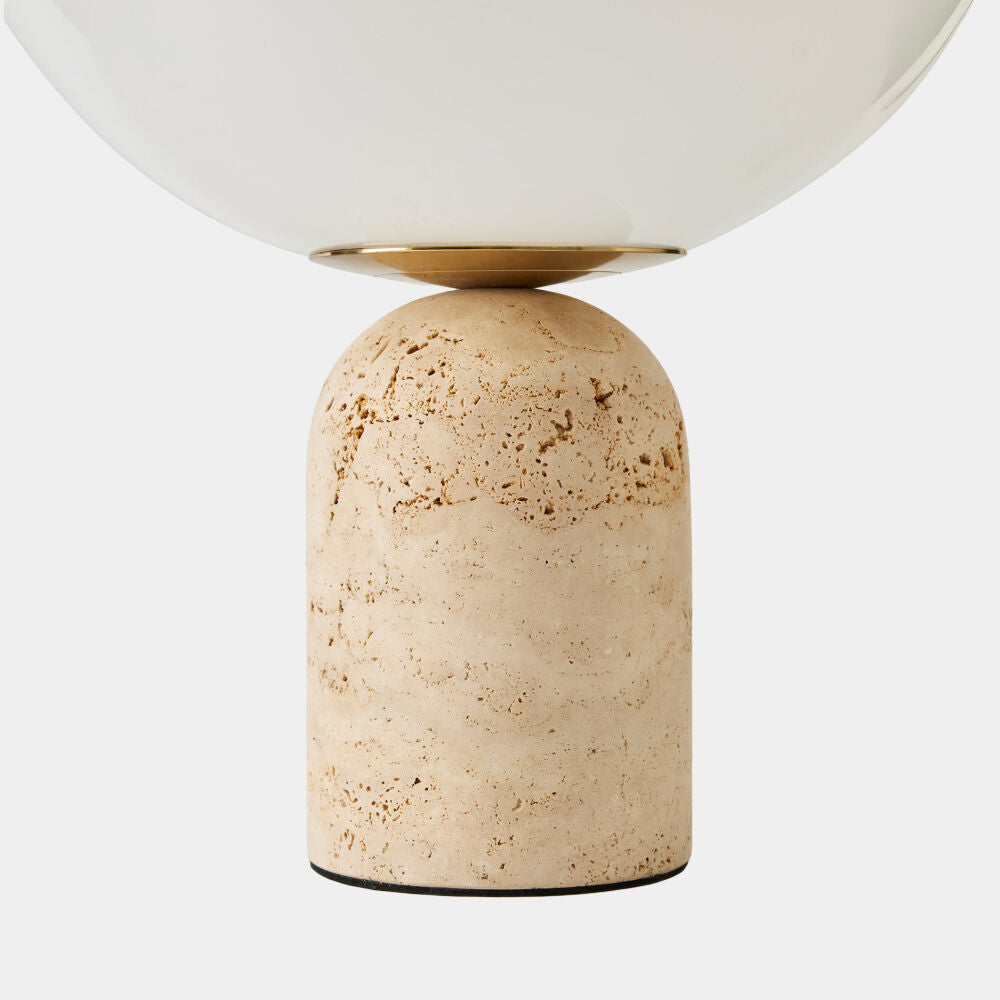Table lamp with a beige terracotta base and white shade on a light gray background