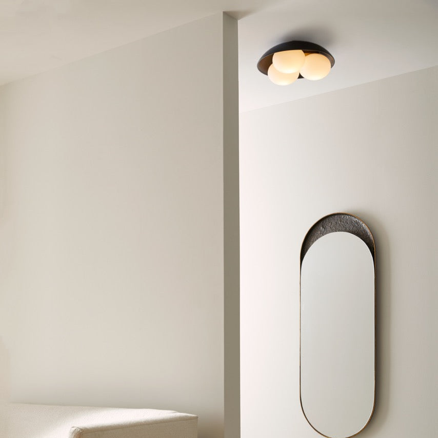 Modern interior with a white wall, round mirror, and a piece of furniture.