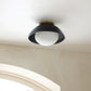 Ceiling light fixture on a white ceiling with a window in the background