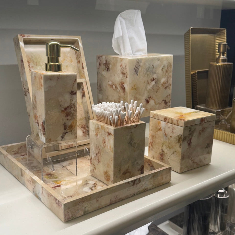 Marble-textured bathroom accessory set on a reflective surface