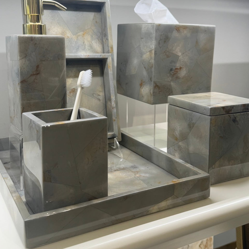 Gray marble bathroom vanity set including a soap dispenser, toothbrush holder, tissue box cover, and storage box on a matching tray, displayed on a bathroom shelf.