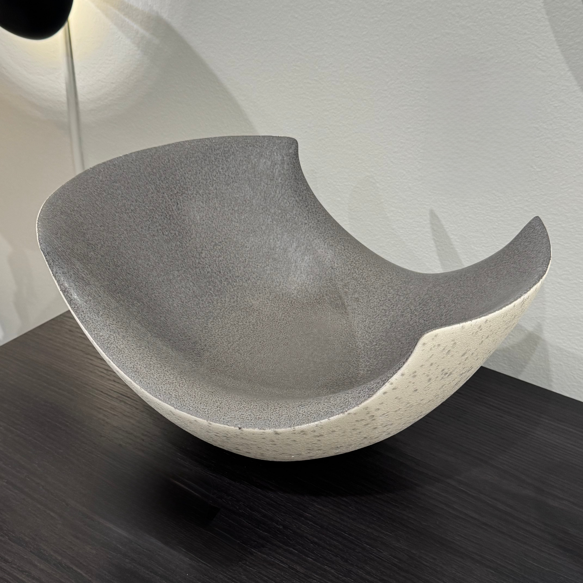 Ceramic bowl with a textured surface on a dark wooden surface