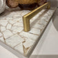 Brass handle on a marble surface with decorative elements in the background
