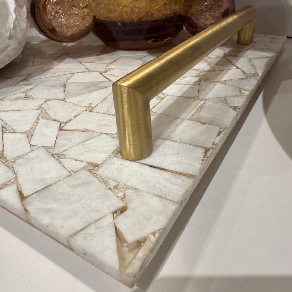 Brass handle on a marble surface with decorative elements in the background