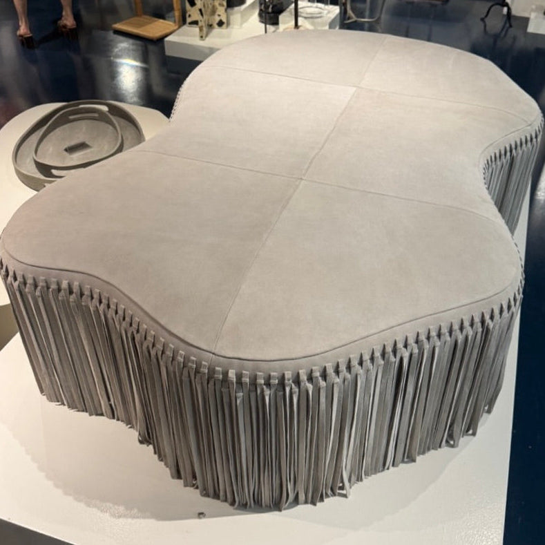 Modern, unique chair with fringe design on a white platform in an indoor setting