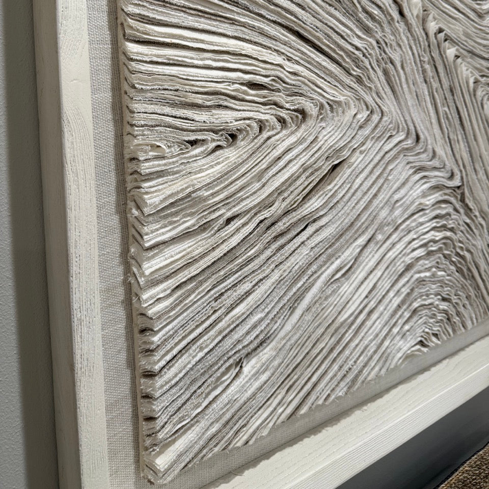 Close-up of a textured wall art piece with a neutral color palette.