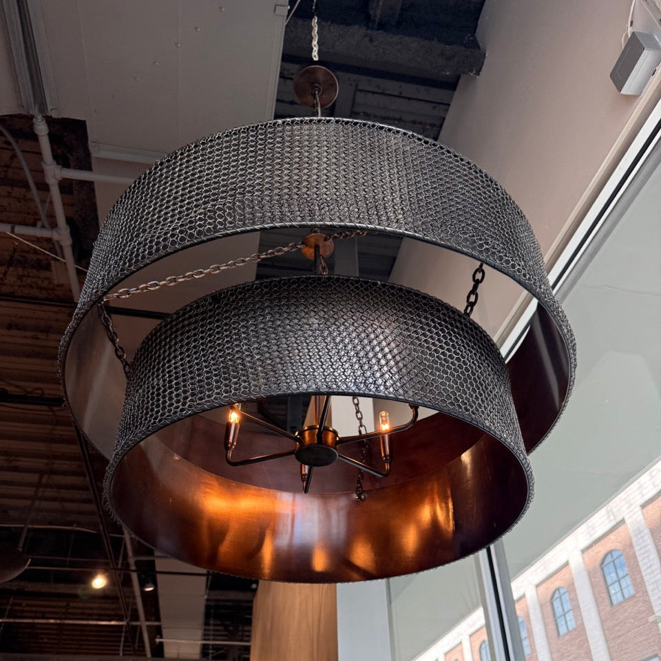 Modern chandelier hanging in a room with large windows