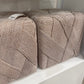 Two textured pillows on a shelf with a neutral background