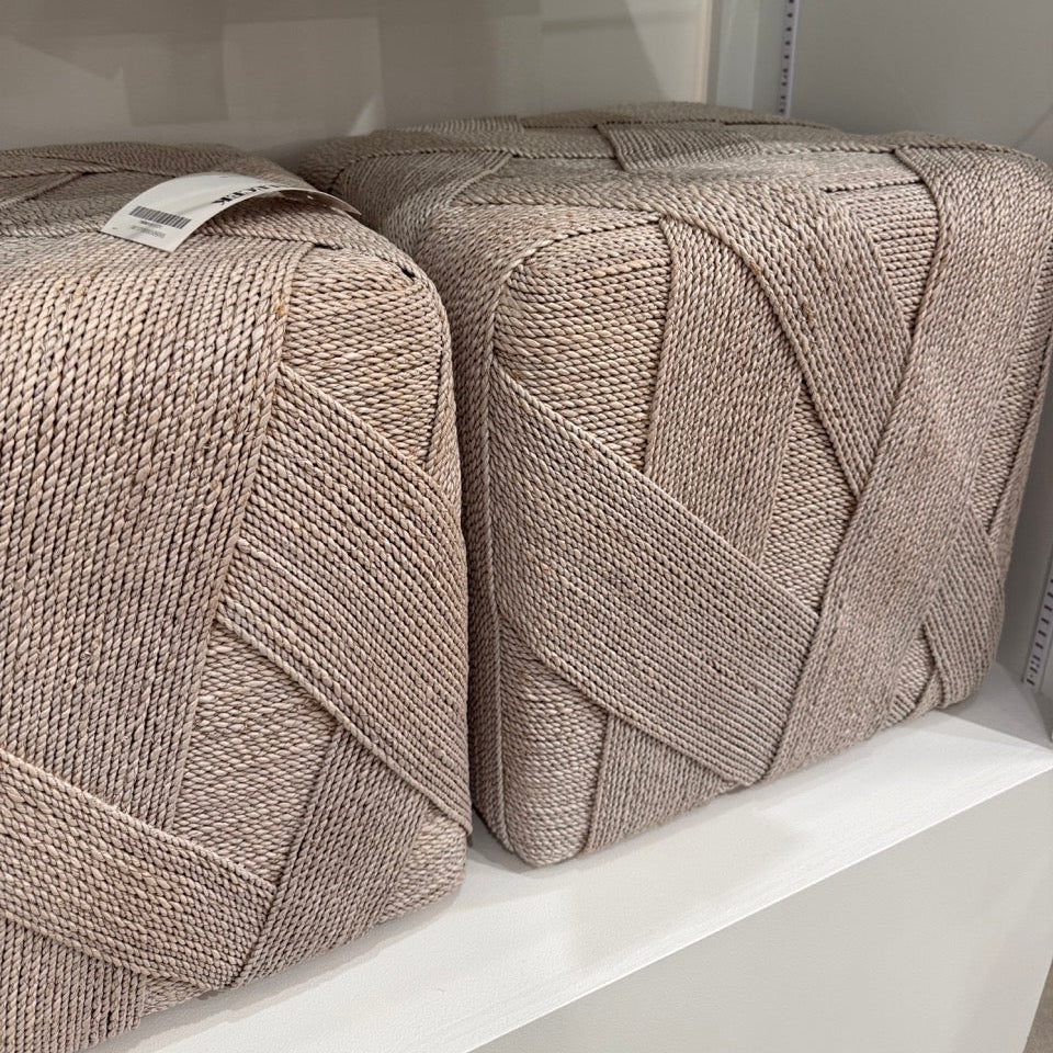 Two textured pillows on a shelf with a neutral background