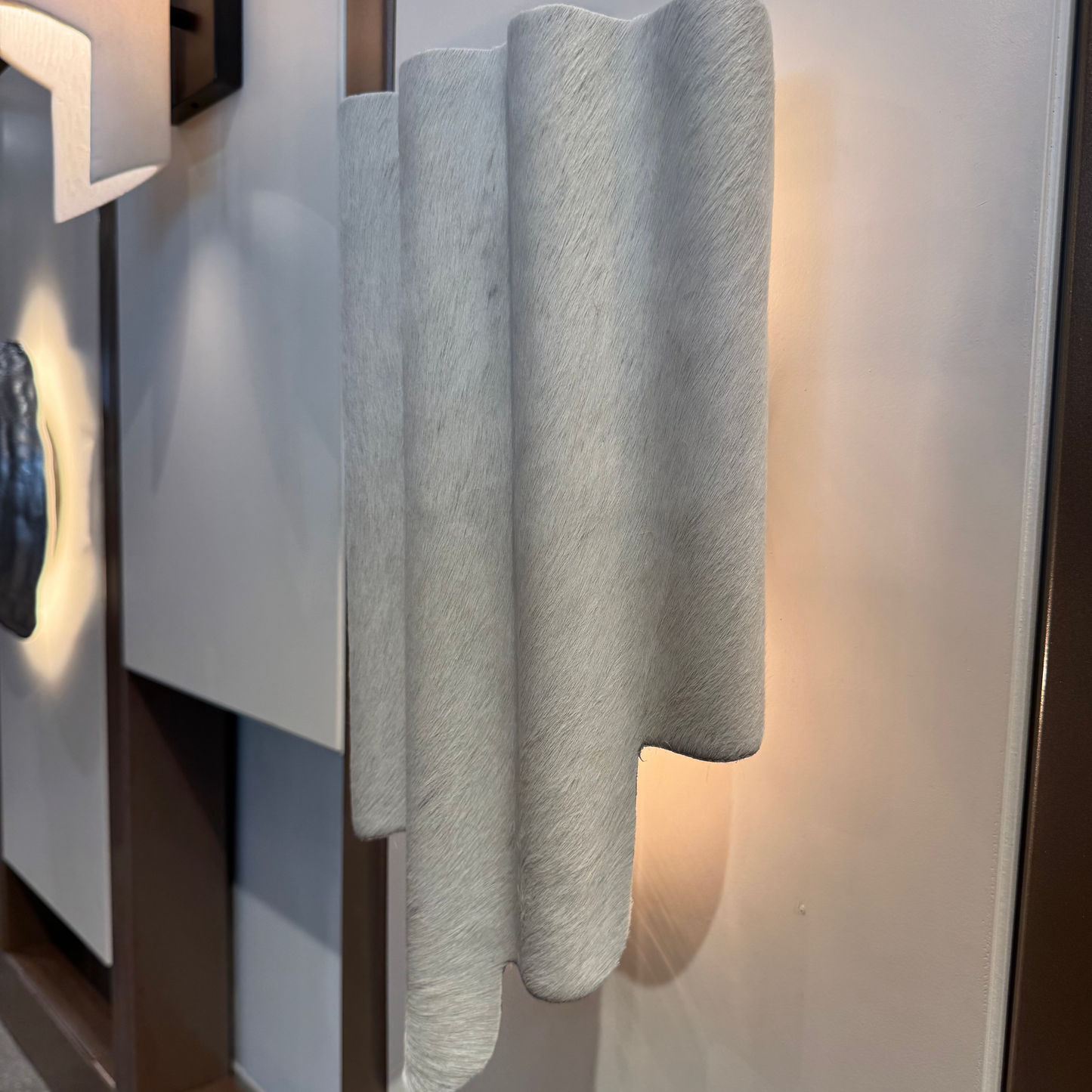 Decorative wall sconce with textured design on a neutral background