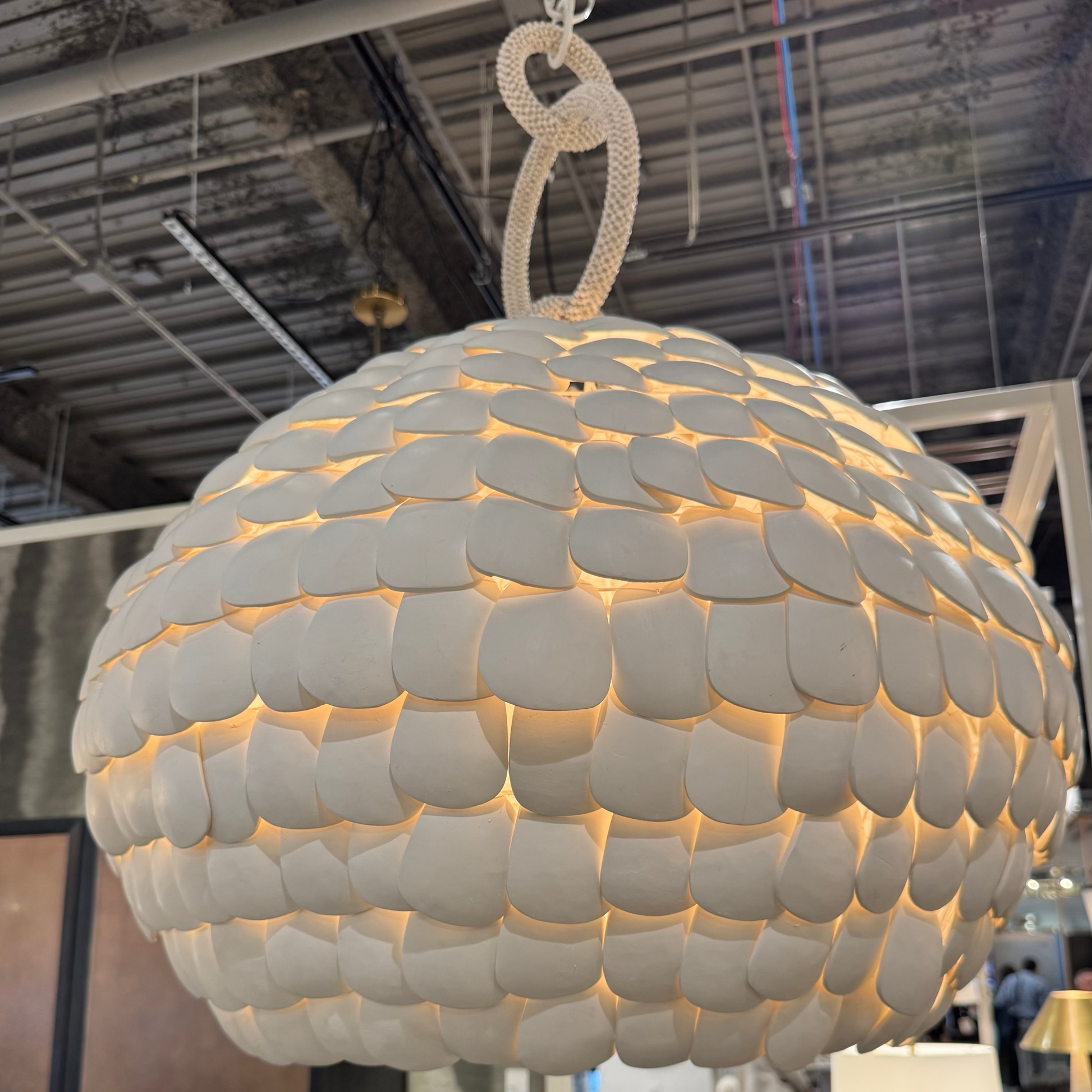 Large spherical pendant light with a textured surface in an indoor setting