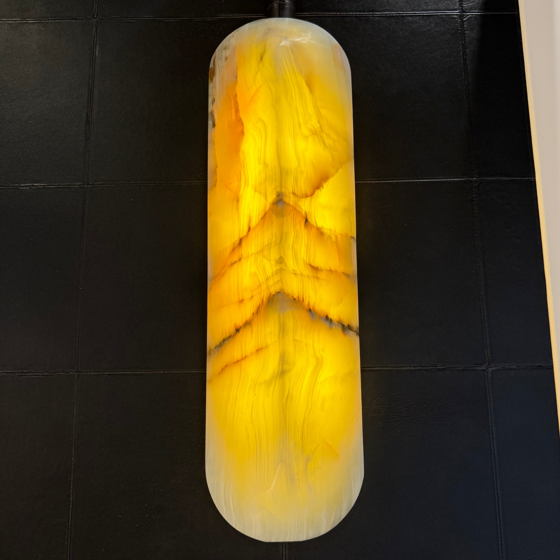 Decorative stone with yellow and white patterns on a black tiled surface