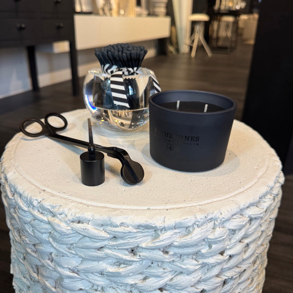 Black container and measuring tools on a textured white surface with a blurred indoor background
