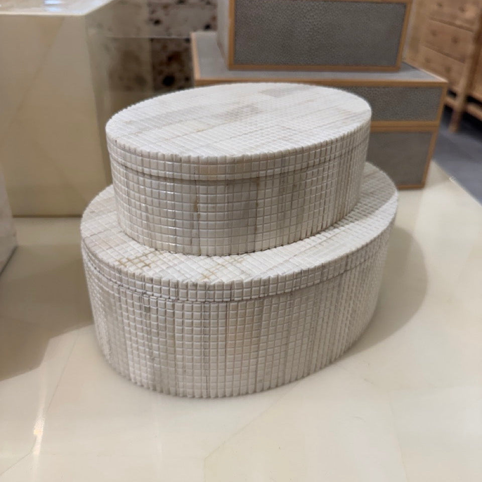 Two tiered woven storage box on a light surface with blurred background