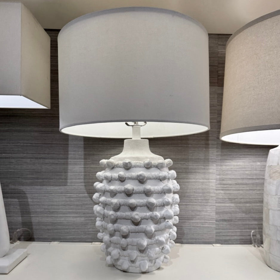 Decorative table lamp with textured base on a white surface