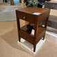 Wooden side table with two drawers in a showroom setting