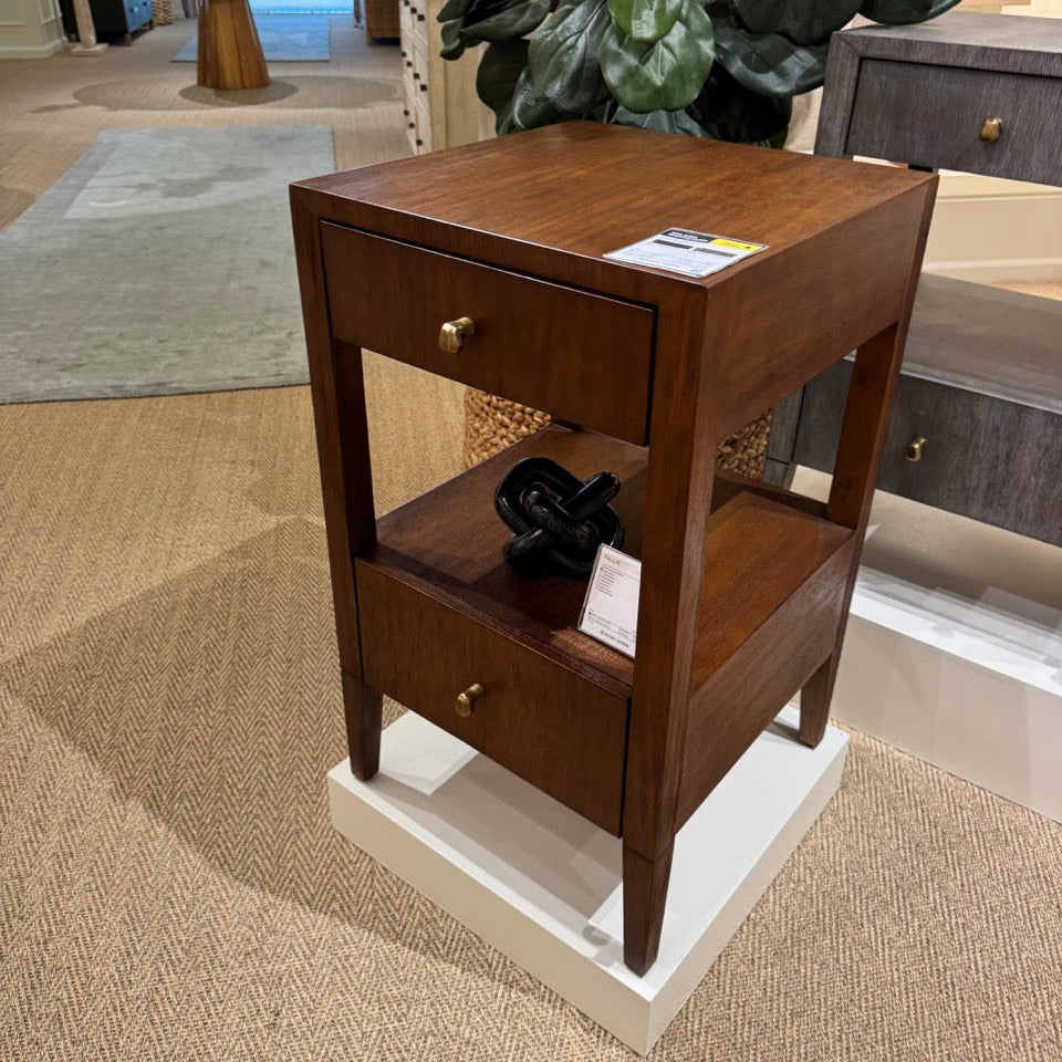 Wooden side table with two drawers in a showroom setting