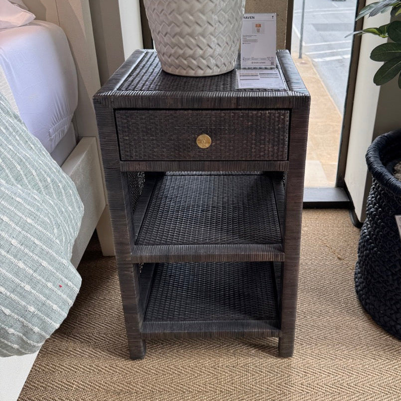 Side table with textured lamp and plant in a room setting