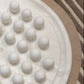 White spherical objects on a textured surface with a striped background