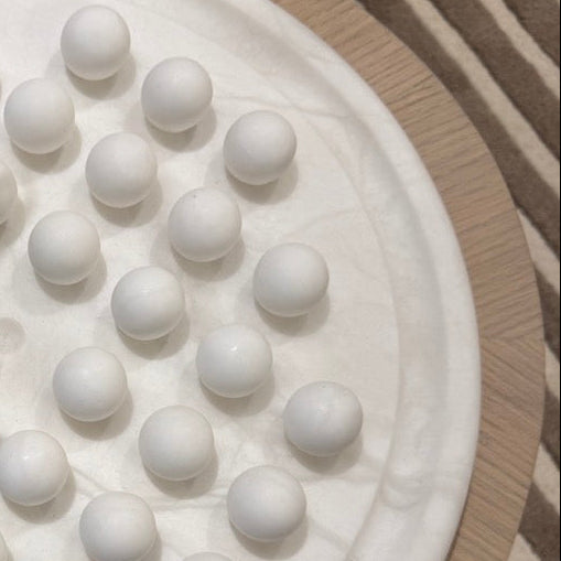 White spherical objects on a textured surface with a striped background