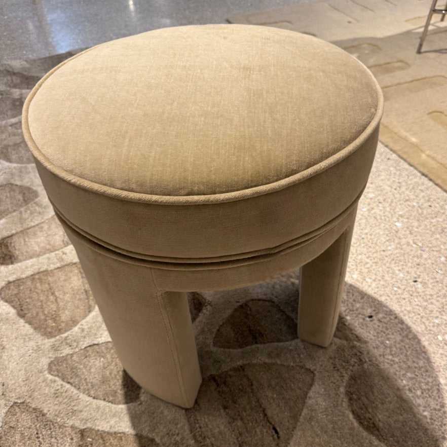 Beige round stool on a patterned carpet