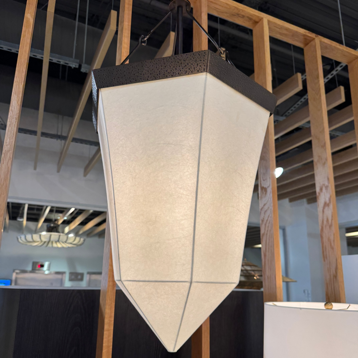 Modern pendant light hanging in a room with wooden beams