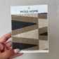 Moss Home fabric swatch with geometric pattern held by a hand against a neutral background