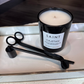 Candle with 'Saint Cazetan' label and tongs on a reflective surface