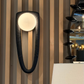 Modern wall-mounted light fixture with a striped wall background