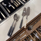 Collection of silverware including forks, spoons, and knives in a drawer.
