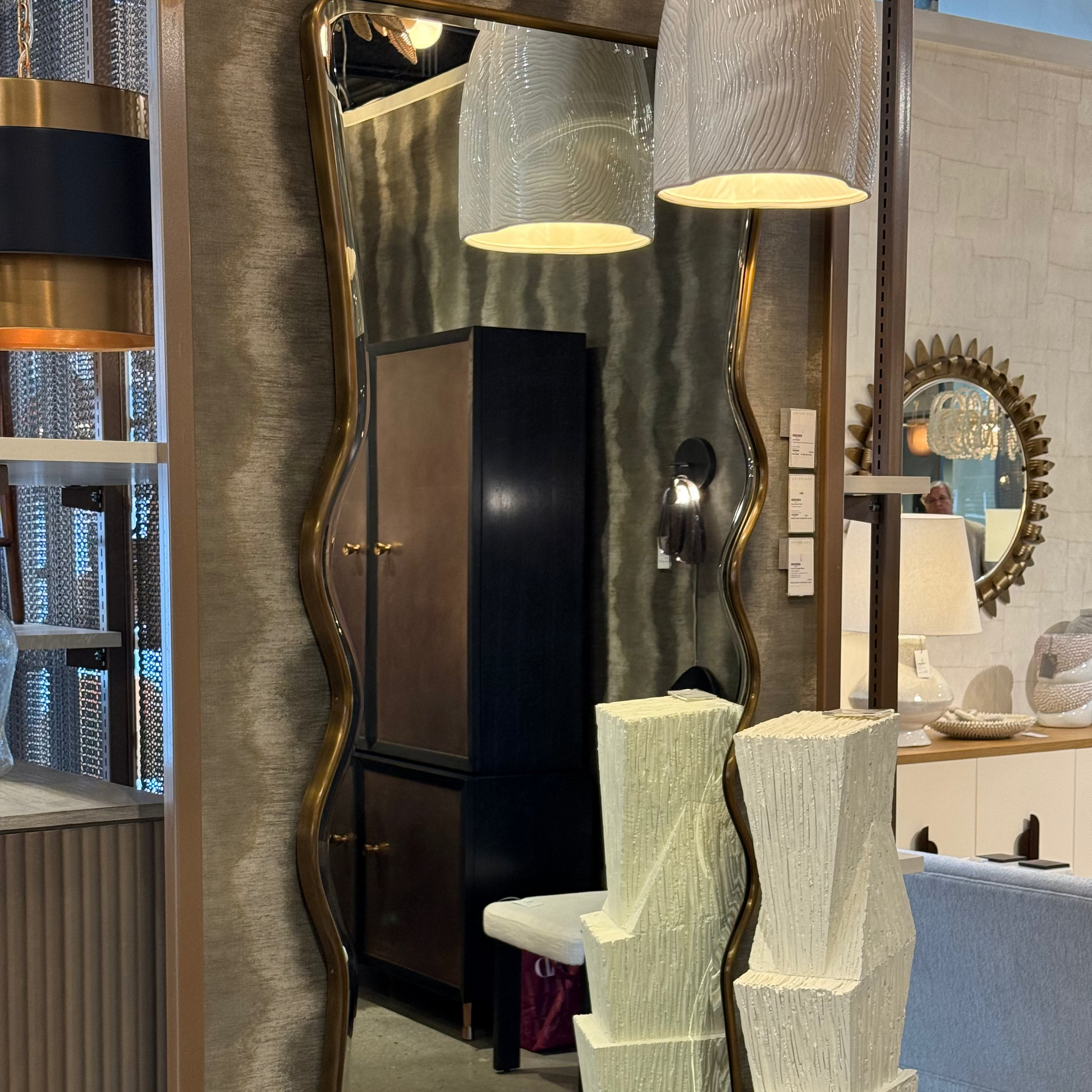 Decorative mirror with wavy frame in a showroom setting