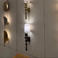 Decorative wall sconces with unique designs on a light-colored wall.