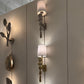 Decorative wall sconces with unique designs on a light-colored wall.