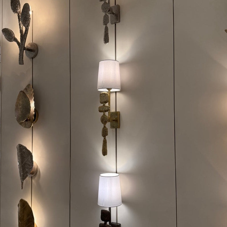 Decorative wall sconces with unique designs on a light-colored wall.