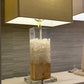 Table lamp with a wooden base and glass accents on a neutral background