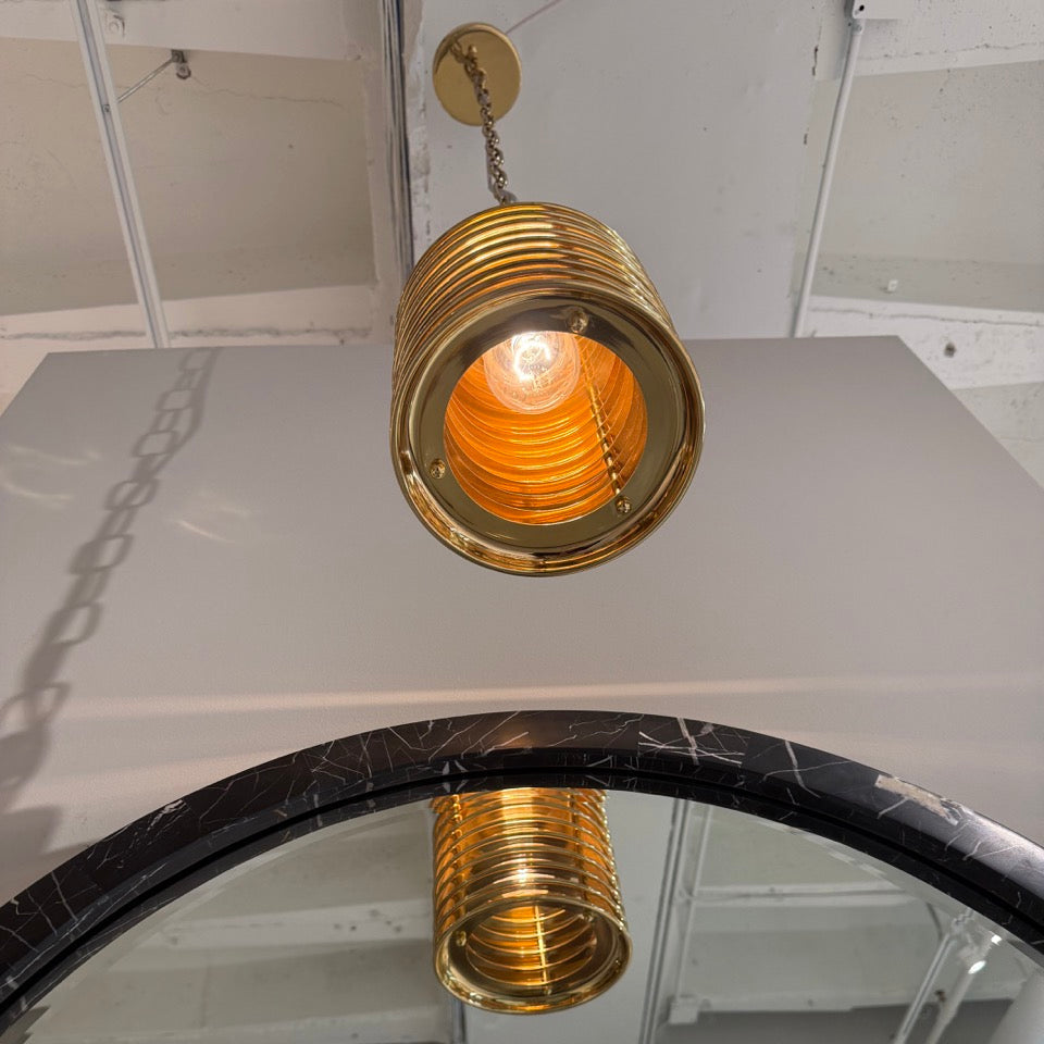 Gold pendant light fixture hanging from a ceiling