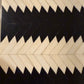 Pattern of black and white chevron shapes on a textured surface