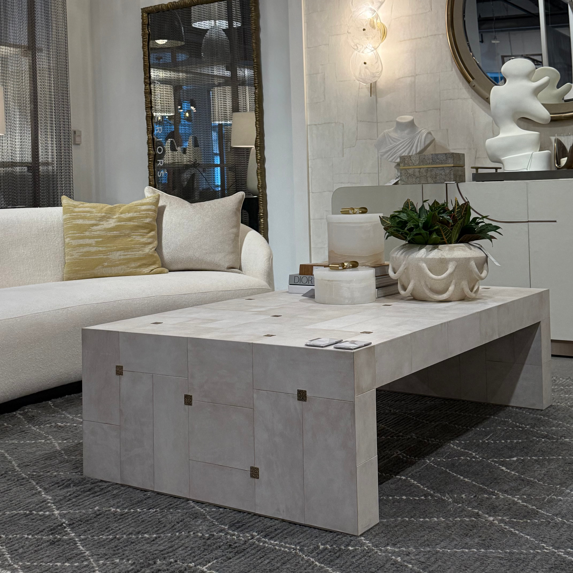 Modern living room with a white sofa, marble coffee table, and decorative elements.