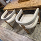 White chairs around a wooden dining table with a rug on the floor.