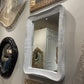 Collection of decorative mirrors with unique frames on a wall.