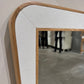 Mirror with a textured white frame on a neutral wall