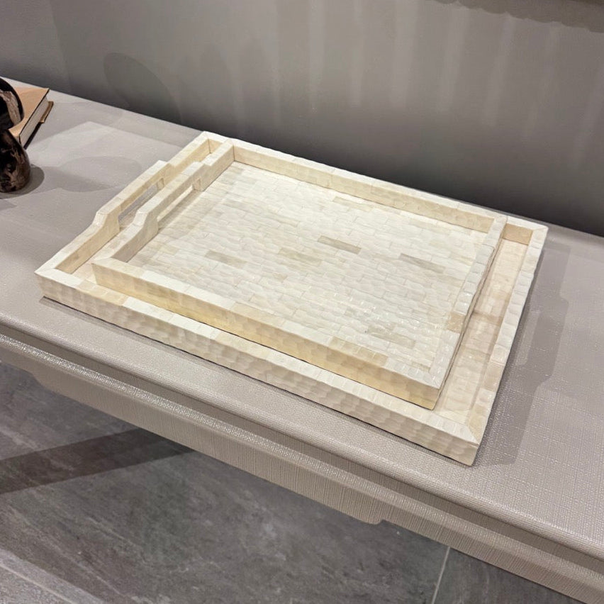 Decorative marble tray on a gray surface with a mirror in the background