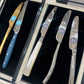 Set of knives with different handles and blade designs in a case.