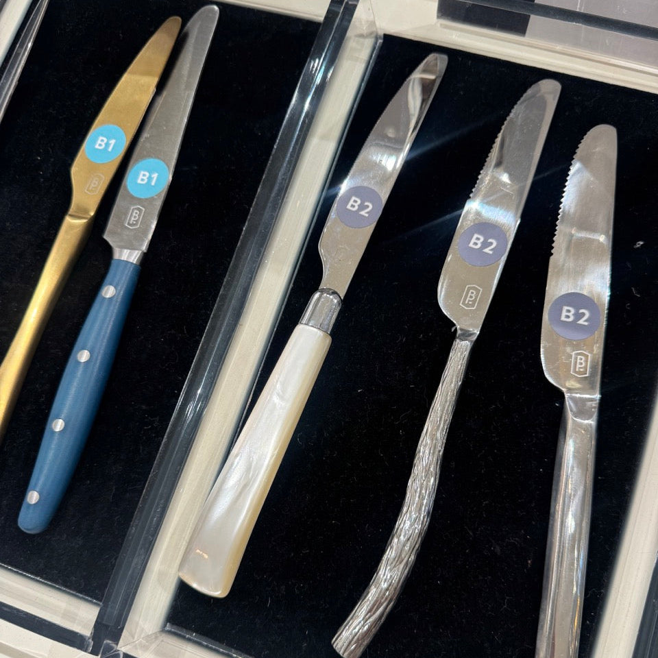 Set of knives with different handles and blade designs in a case.
