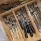 Set of silverware in a wooden drawer organizer