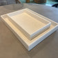 Two white ceramic trays on a gray surface