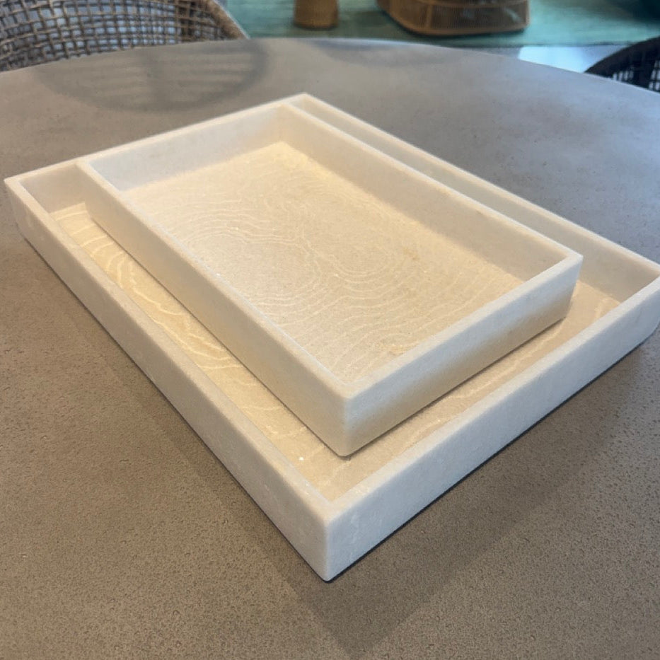 Two white ceramic trays on a gray surface