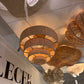 Chandelier with woven design hanging in a showroom with 'LECEK LIGHTING' branding.