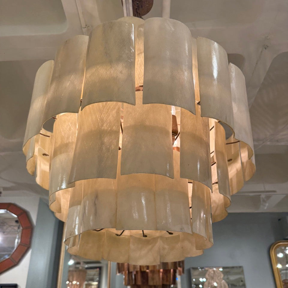 Large chandelier hanging in a room with mirrors and decor